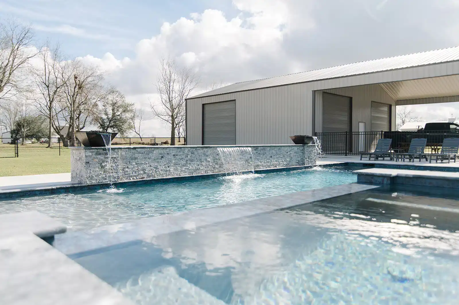 Completed pool with raised stone wall and water features