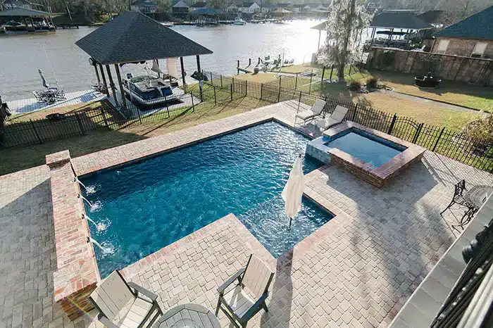Completed pool and spa beside a waterfront backyard
